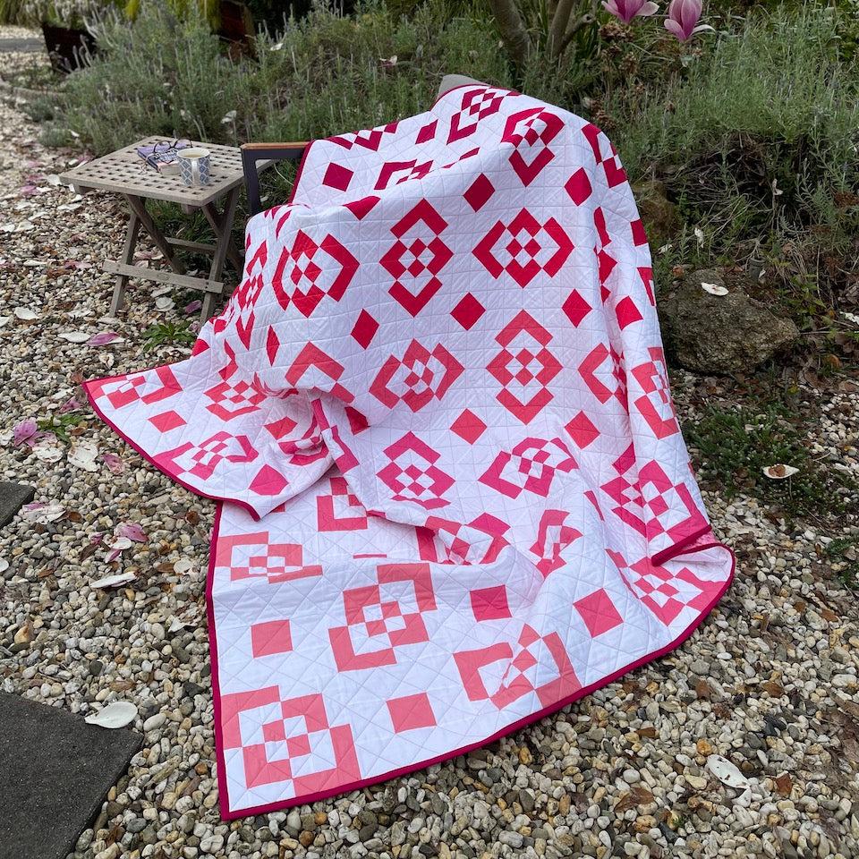 Bento Box Quilt draped over a chair in the garden