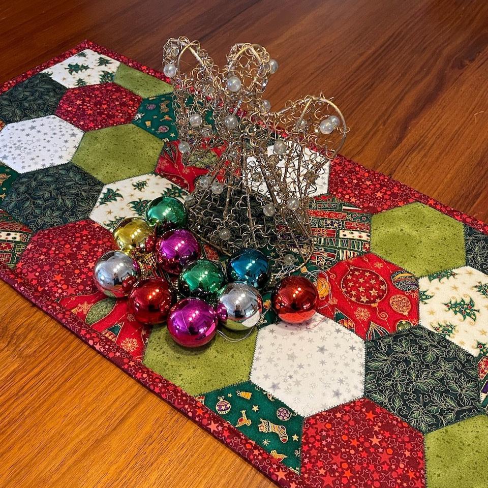 The table runner on a table styled with Christmas decorations