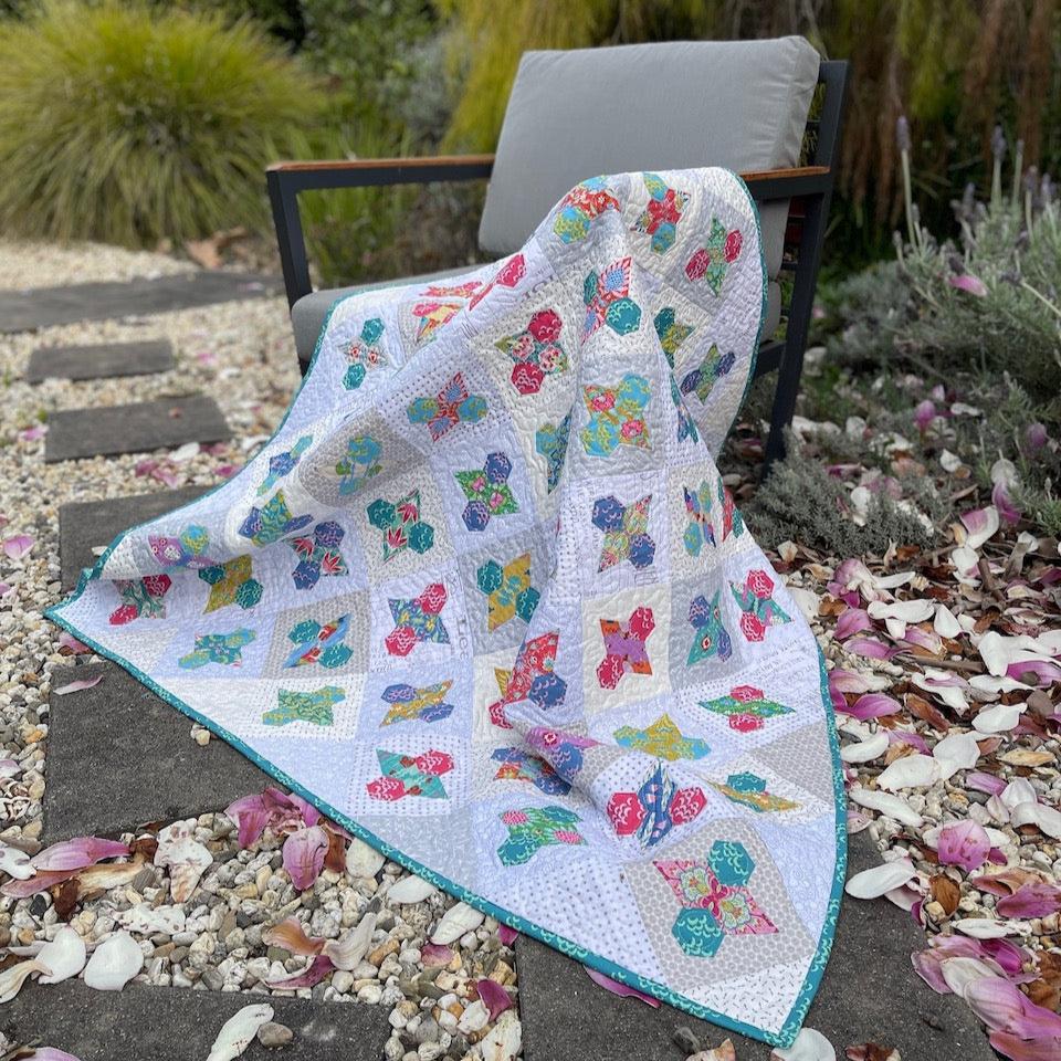 Let it Bee Quilt draped over a chair in the garden