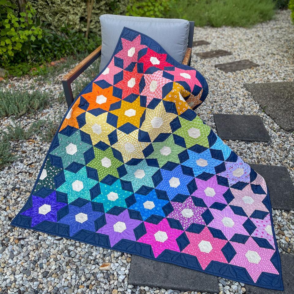 The Night Blooms Quilt draped across a chair in the garden