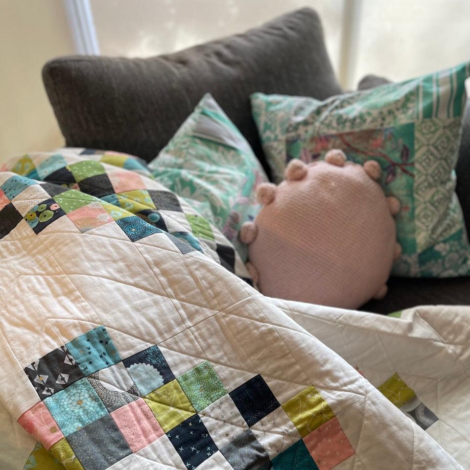 Closeup of Rough Diamond quilt with small cushions in the background.