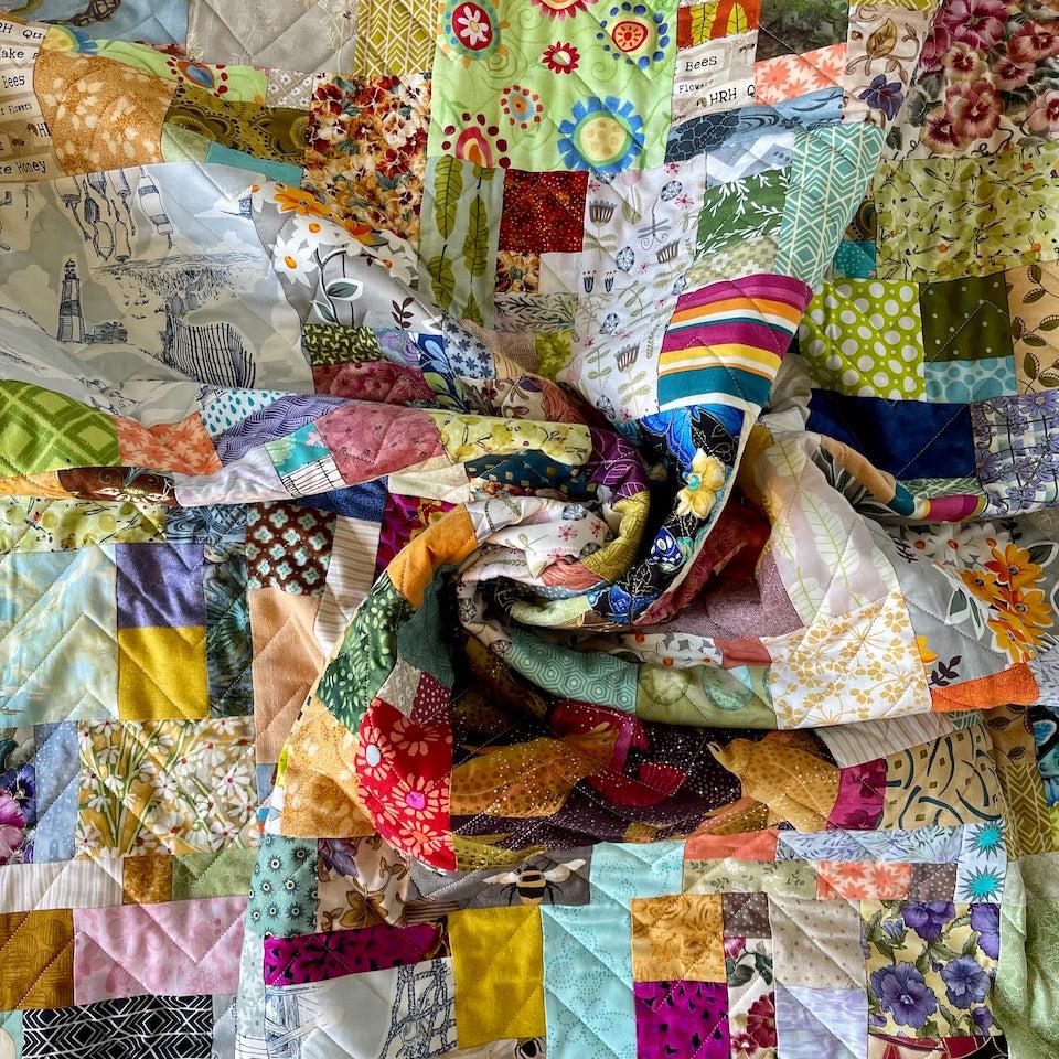 A close up of a scrunched Scrap Quilt showing the colours