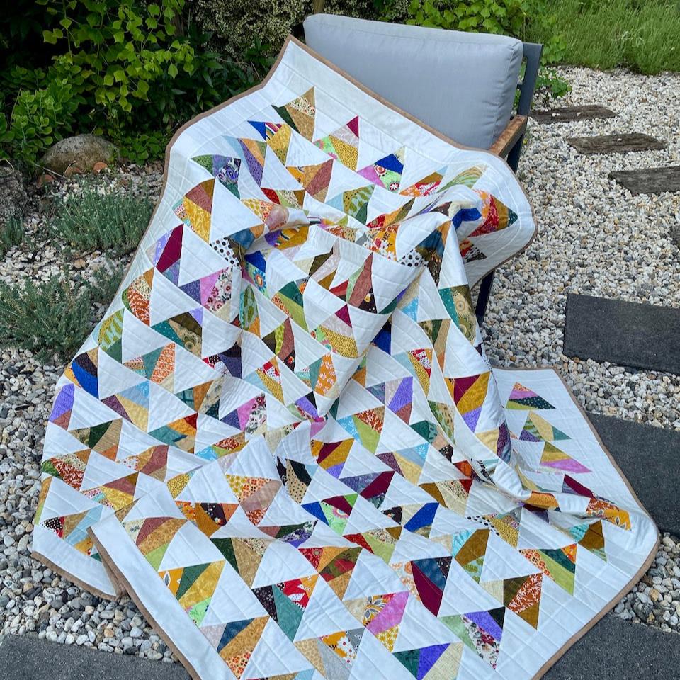 The Triangle Quilt draped over a chair in the garden